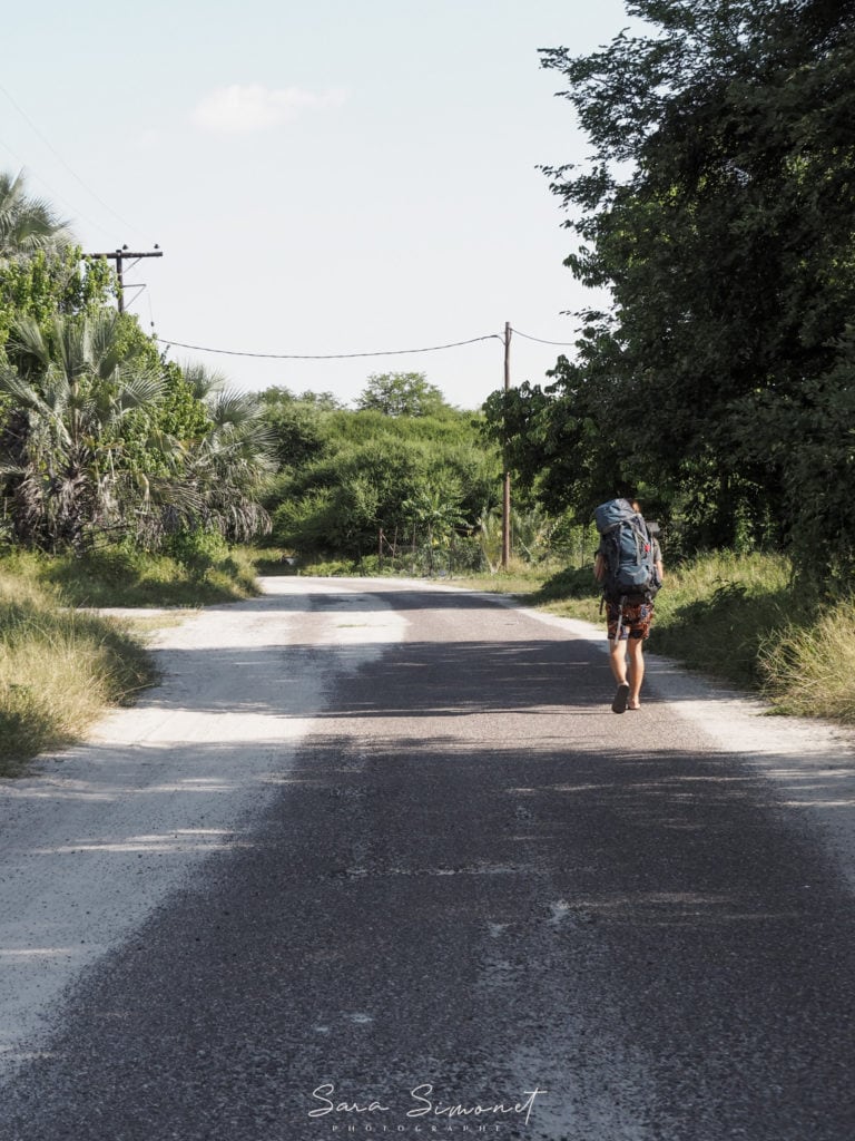 Backpacker qui marche sur une route déserte à Maun au Botswana